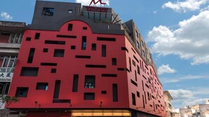 Un bâtiment moderne à la façade rouge, doté de nombreuses fenêtres et d’une enseigne « China Selang » au niveau du rez-de-chaussée.