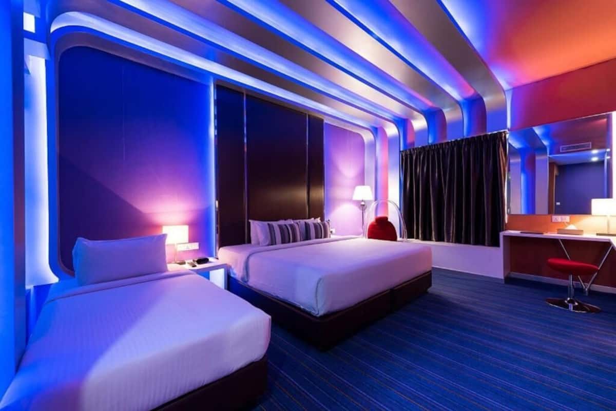 Una habitación de hotel moderna con dos camas, un escritorio y una silla.