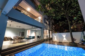 A modern building with a rooftop pool, outdoor seating area, and a staircase leading to the upper floor. - Royal 78 Backpackers Bar & Restaurant (Anjuna)