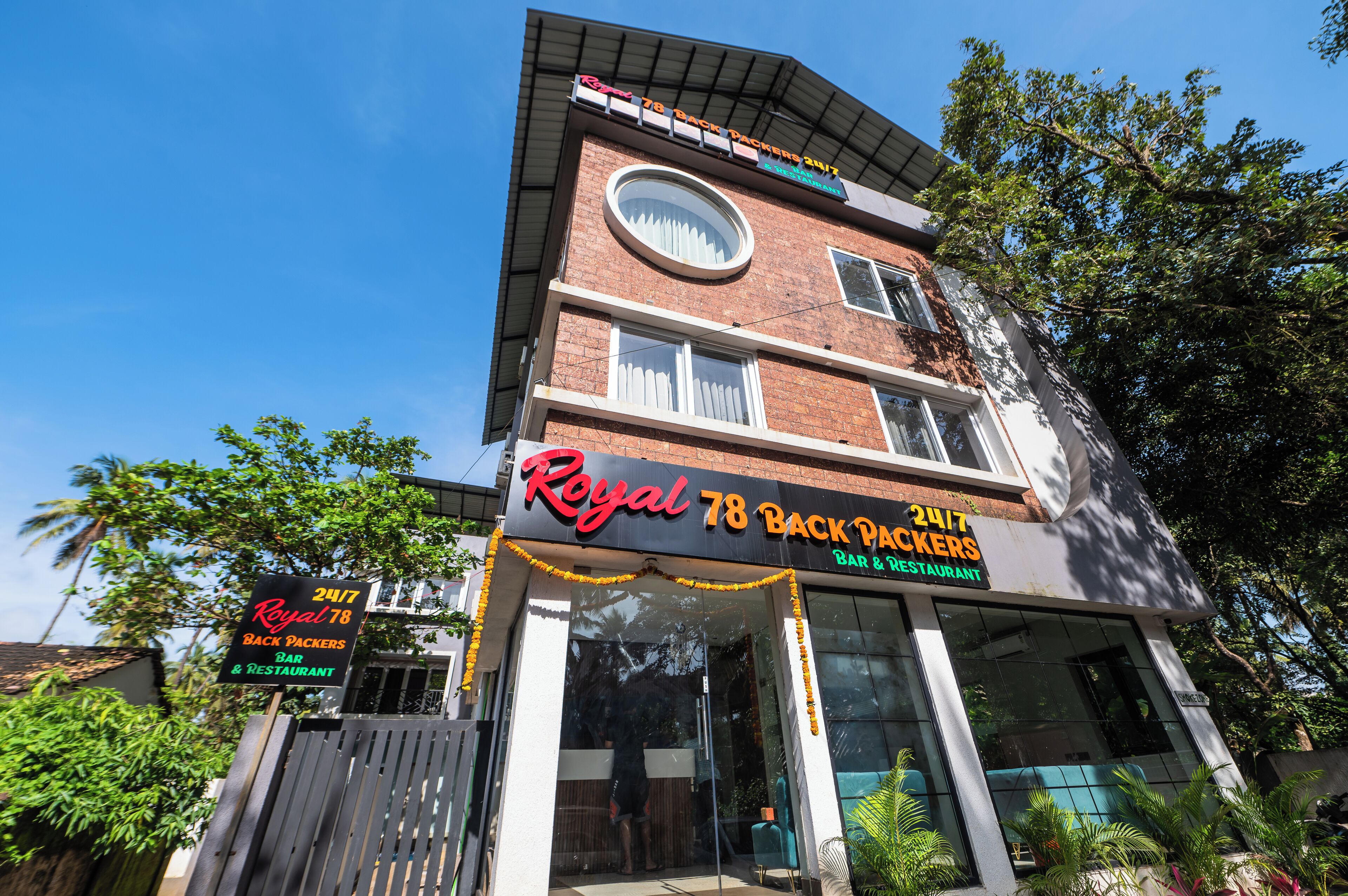 A multi-story building with a prominent sign for 'Royal 78 Back Packers 2017 Bar & Restaurant'.