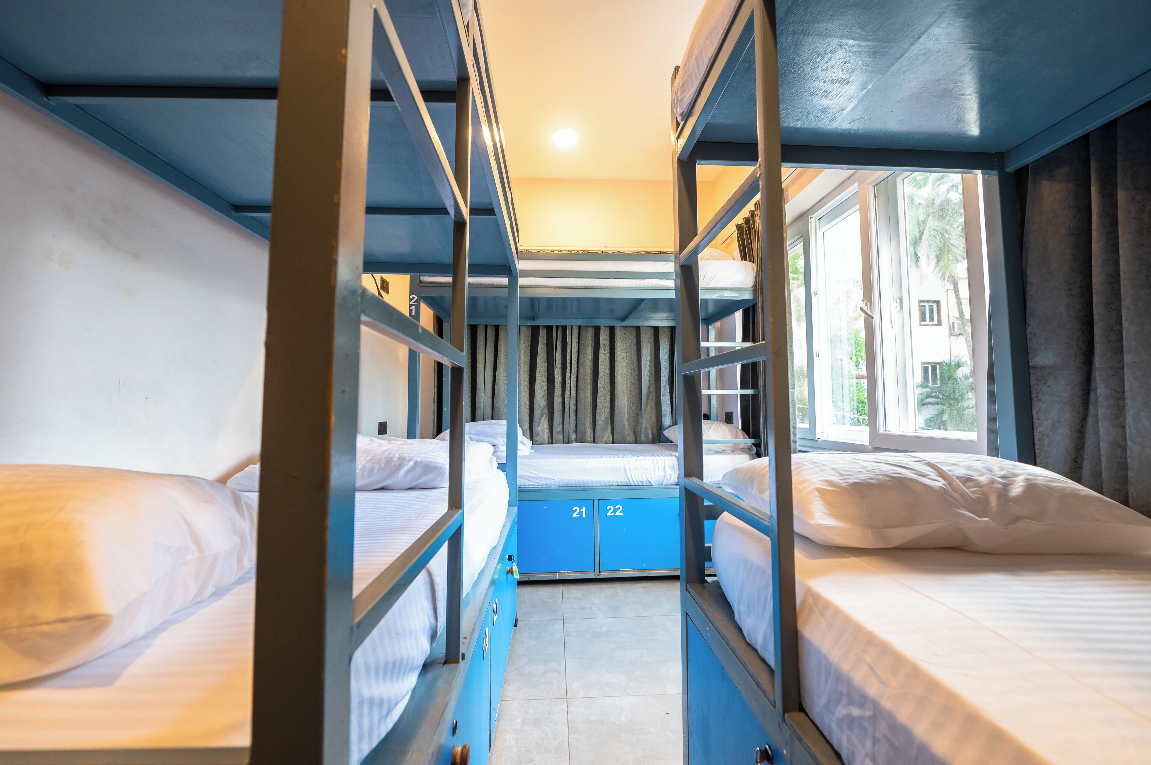 A bunk bed room with a window and curtains.