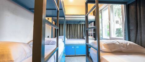A bunk bed room with a window and curtains.