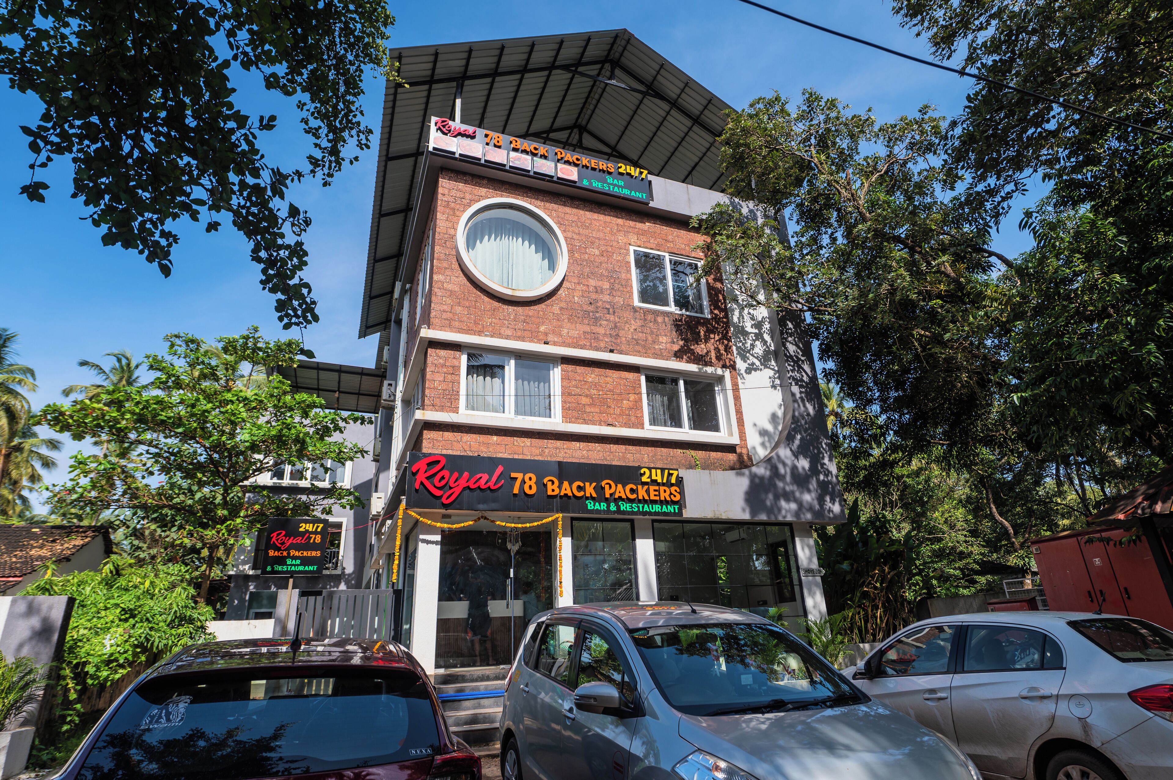 A two-story building with a sign for 'Royal 78 Back Packers 24/7 Bar & Restaurant'.
