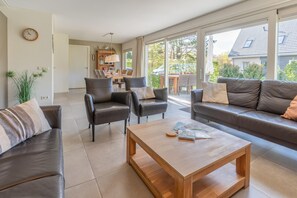 Un salon spacieux avec un canapé, des fauteuils et une table basse.