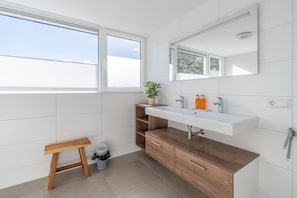 A modern bathroom with a wooden vanity, white sink, and a large mirror. - Tastefully Furnished Country House for 6 People (Den Burg)