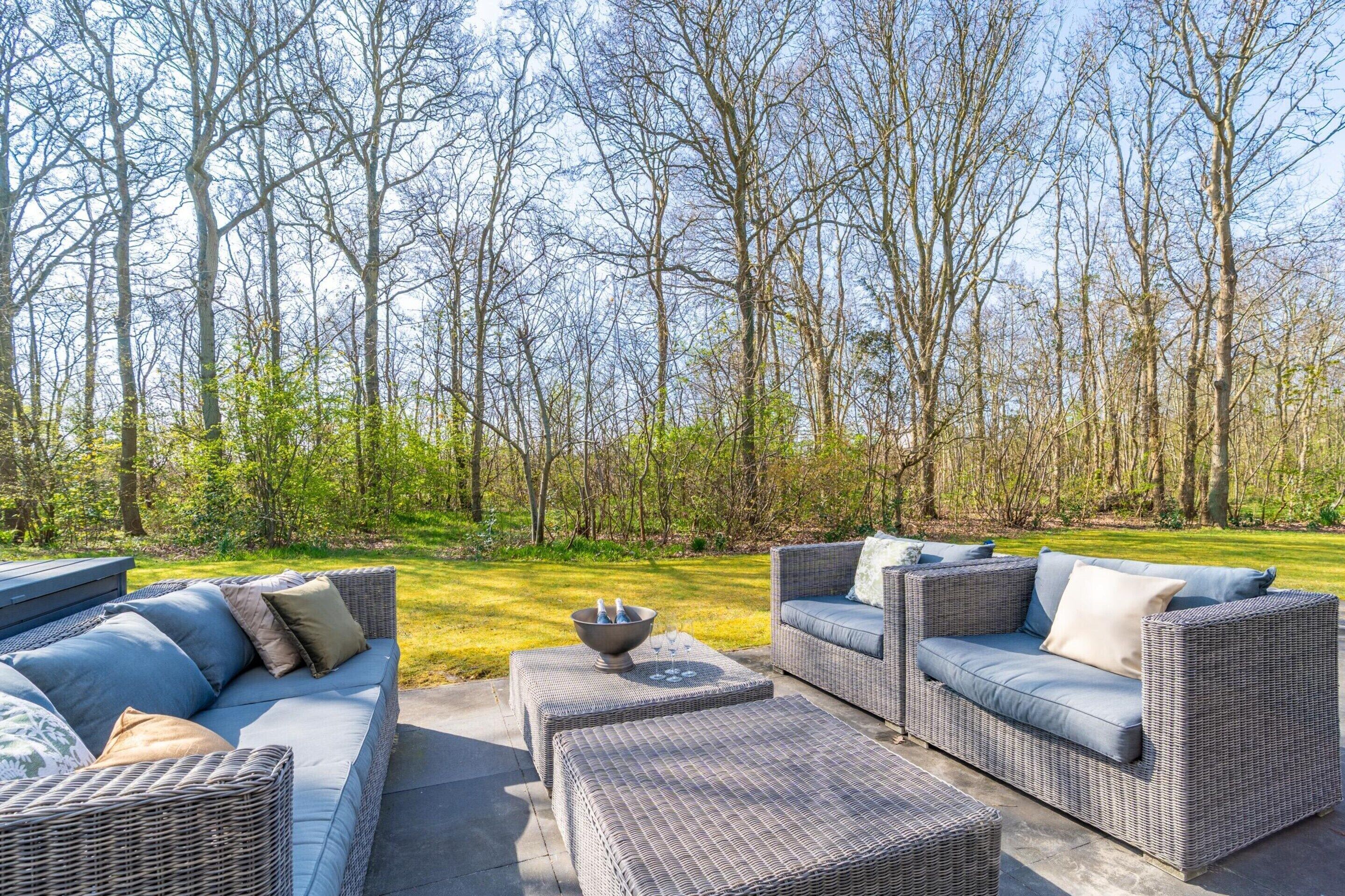 An outdoor seating area with wicker furniture and a fire pit.