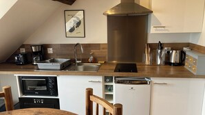 Une cuisine moderne équipée d’un lave-vaisselle, d’un four et d’une machine à café intégrés.