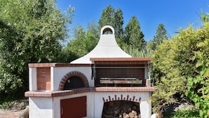 A brick-built outdoor oven with a chimney, surrounded by greenery. - Ferienwohnung in Bensersiel, 300 m vom Strand Entfernt (Esens)