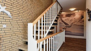 A staircase with white railings and a brick wall. - Ferienwohnung in Bensersiel, 300 m vom Strand Entfernt (Esens)