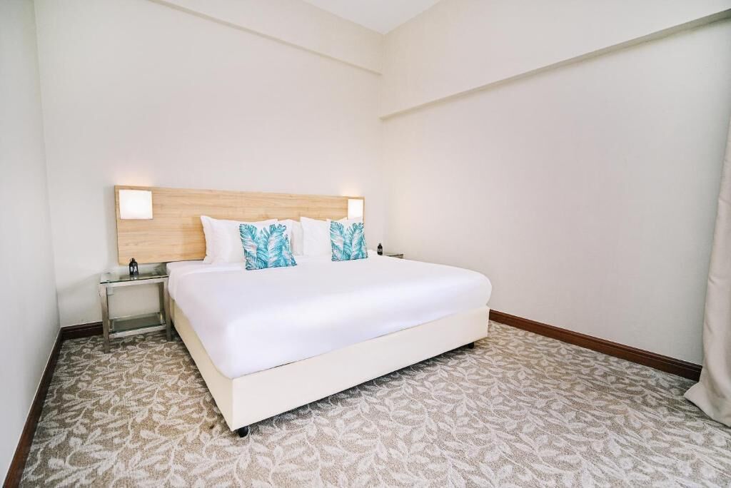 Ein Hotelzimmer mit einem großen Bett, einem Nachttisch und einer Wandlampe.