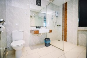 Ein modernes Badezimmer mit Toilette, Waschbecken und einer Duschkabine aus Glas.