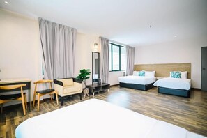 Ein Hotelzimmer mit zwei Betten, einem Schreibtisch, einem Stuhl und einem Spiegel.