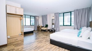 Ein modernes Hotelzimmer mit einem großen Bett, einem Schreibtisch und einem Kleiderschrank.