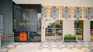 Das Kingston Hotel mit moderner Fassade, großen Glasüren und einem strukturierten Design über dem Eingang.