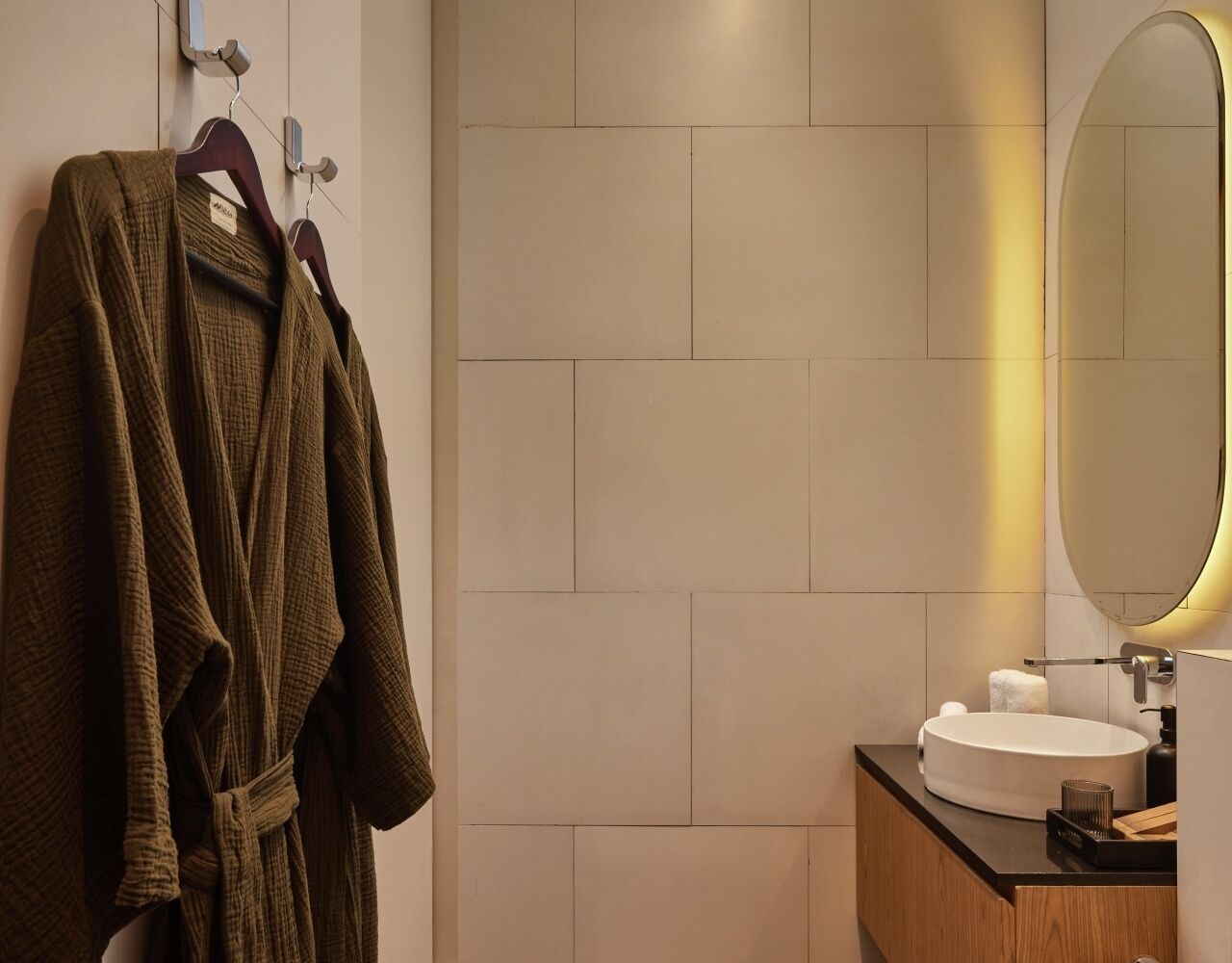 Une salle de bain moderne avec un grand miroir, un lavabo rond et un meuble-lavabo en bois.