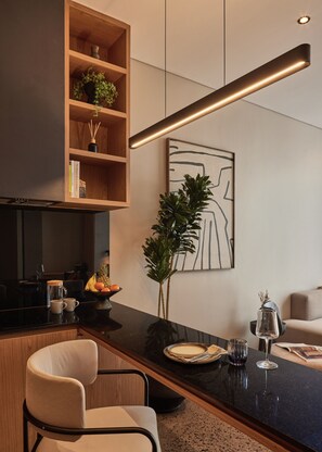 Deluxe studio | Privékeuken | Een koelkast, een kookplaat, een vaatwasser, kookgerei, borden en bestek