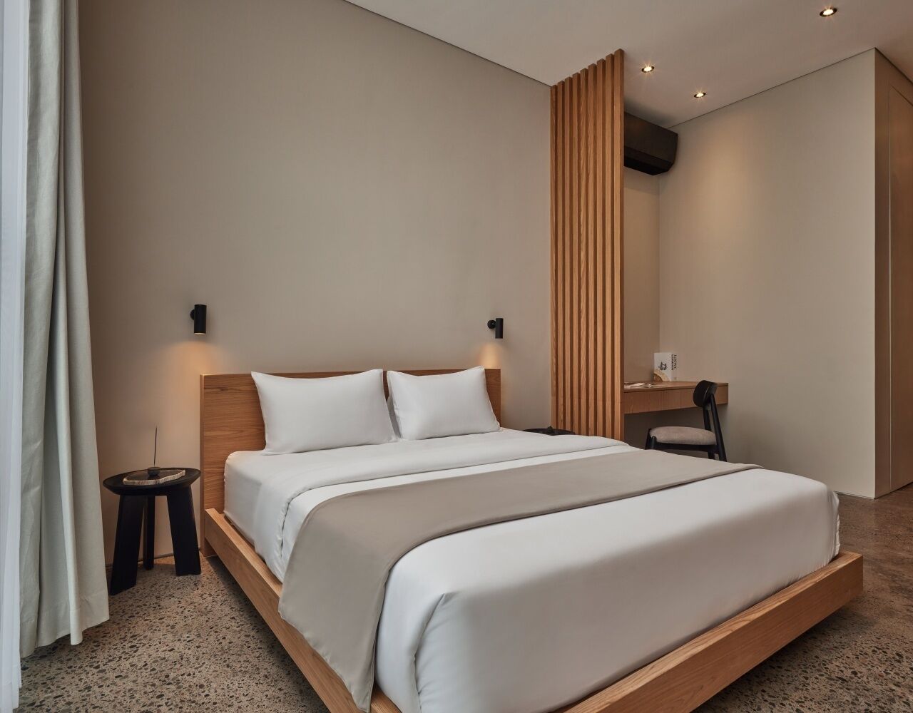 Una moderna camera d'albergo con un letto grande, comodini, una scrivania e una sedia.