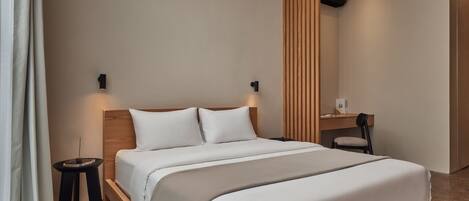 Una moderna camera d'albergo con un letto grande, comodini, una scrivania e una sedia.