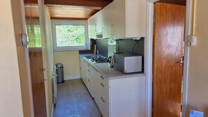 A compact kitchen with a window, a stove, and a sink. - Bungalow for 6 Persons With a Very Spacious South-facing Garden (De Koog)