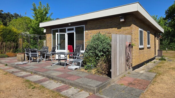 A single-story house with a patio area featuring a table and chairs. - Bungalow for 6 Persons With a Very Spacious South-facing Garden (De Koog)
