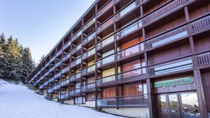 A multi-story hotel with balconies, a sign reading "LES LAUZIÈRES," and a snowy landscape. - Studio for 5 People at the Foot of the Slopes (Bourg-Saint-Maurice)