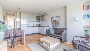 Un salon moderne avec un canapé, une table basse et un coin repas.