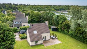 Een woonwijk met huizen, een gazon en een auto op de oprit.