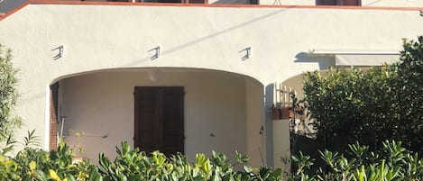 A two-story building with a flat roof, satellite dish, and a small balcony.