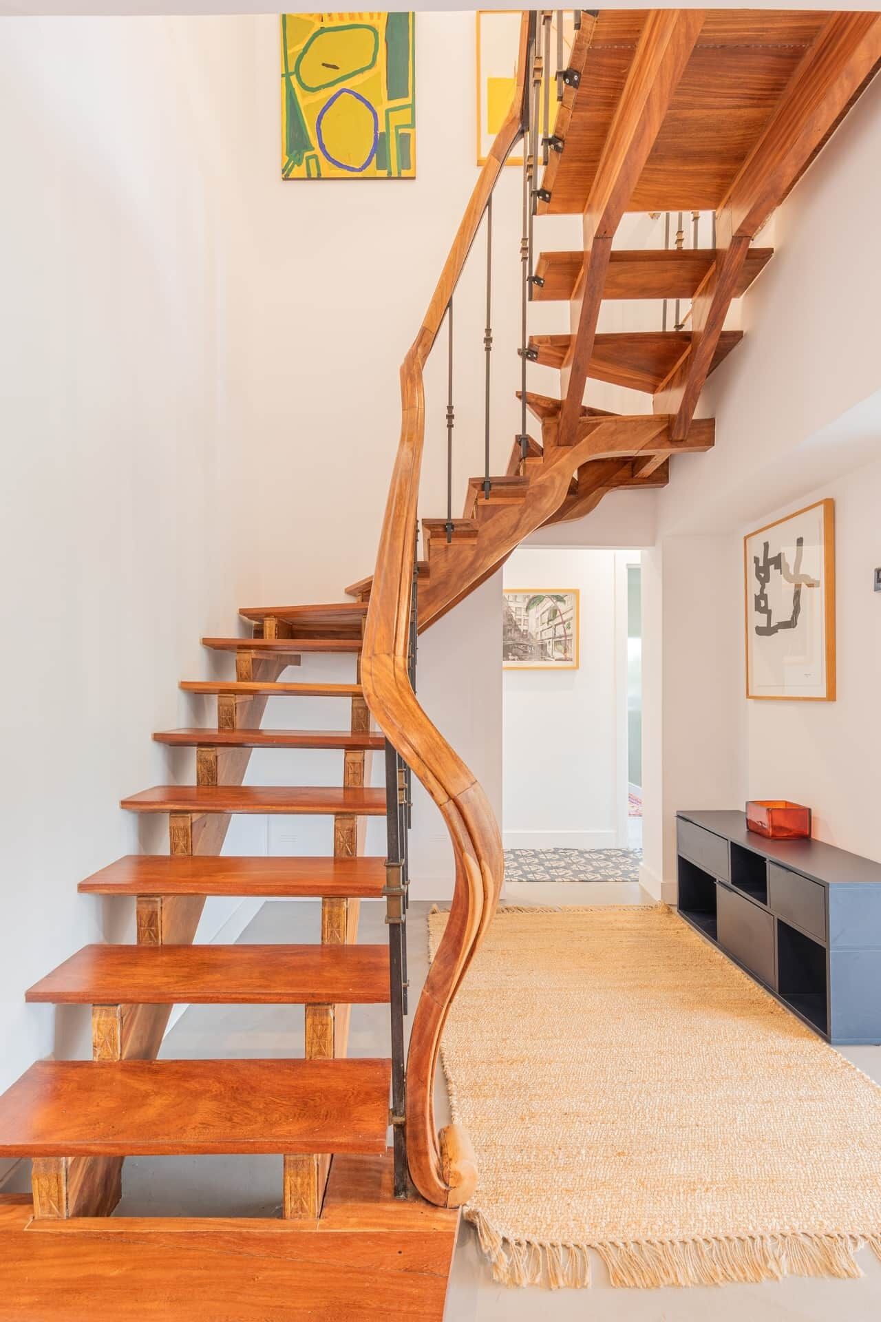 Una scala in legno dalla forma arcuata, che conduce a un piano superiore.