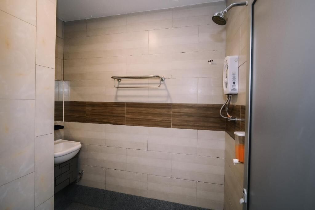 Un baño con lavamanos, toallero y ducha.