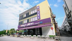 Un hôtel avec une enseigne indiquant « Swing & Pillows » et « espace de vie partagé par ibilik ».