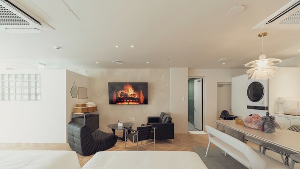A modern hotel room with a fireplace, a dining area, a sofa, and a bed. - Ravenna. 5mis from Myeongdong/shopping/restaurant/beauty/skincare/suitefor10ppl (Seoul)