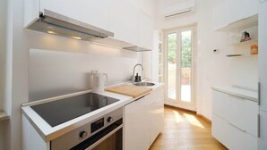Una cocina moderna con estufa integrada, un lavamanos y un ventanal.