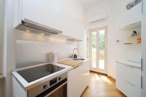 Una cucina moderna con piano cottura integrato, lavello e finestra.