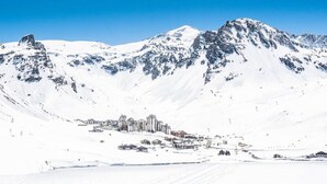 Un paysage montagneux enneigé, avec une ville au premier plan.