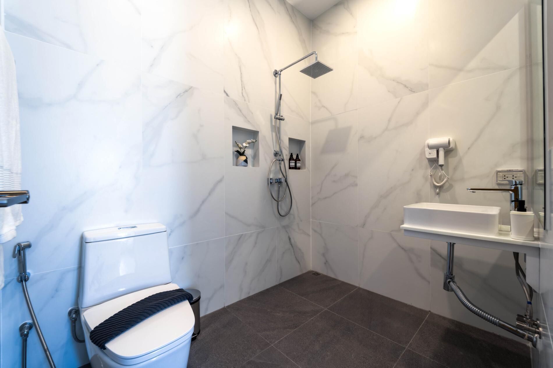 A modern bathroom with a toilet, shower, and sink.