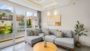 Una sala de estar moderna con un sofá seccional gris, una mesa de centro de madera y una planta en maceta.