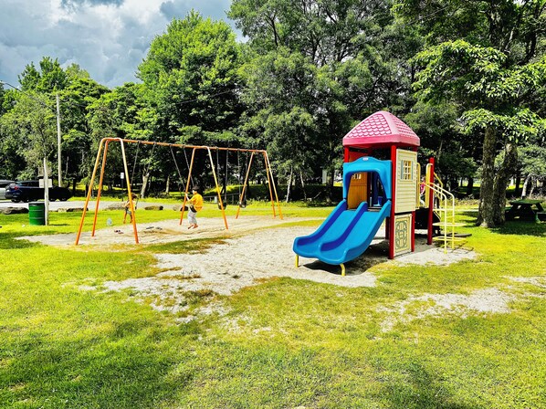Un parque infantil con columpios y un tobogán.