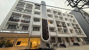 Ein mehrstöckiges Hotel mit modernem Design, mit Balkonen, großen Fenstern und einem markanten Eingang mit einem Schild.