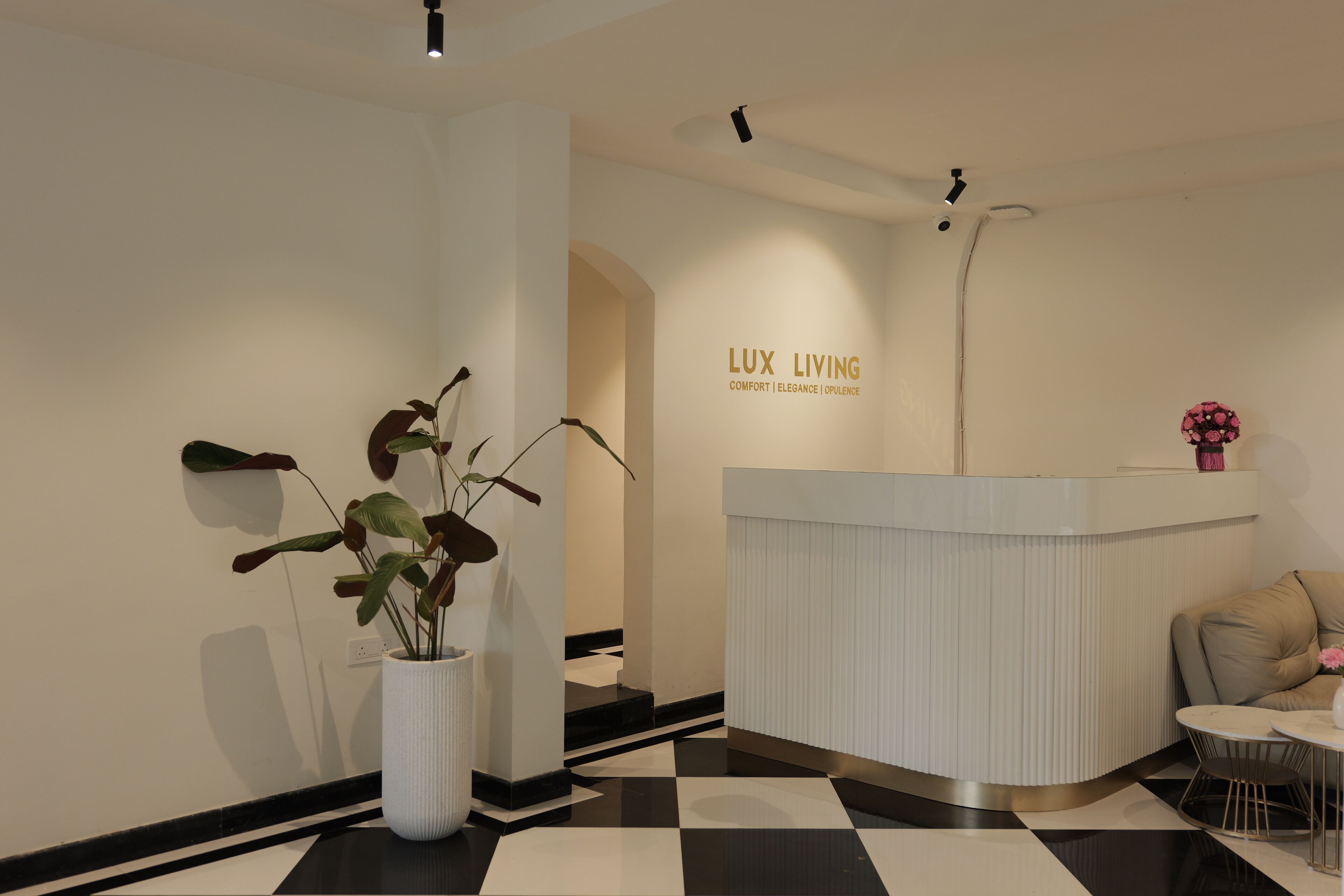 A reception area with a checkered floor, a white reception desk, and a potted plant.