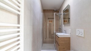 A modern bathroom with a glass-enclosed shower, a wooden vanity, and a white toilet. - Modernly Furnished 6-person Bungalow in the Seaside Resort of De Koog (De Koog)