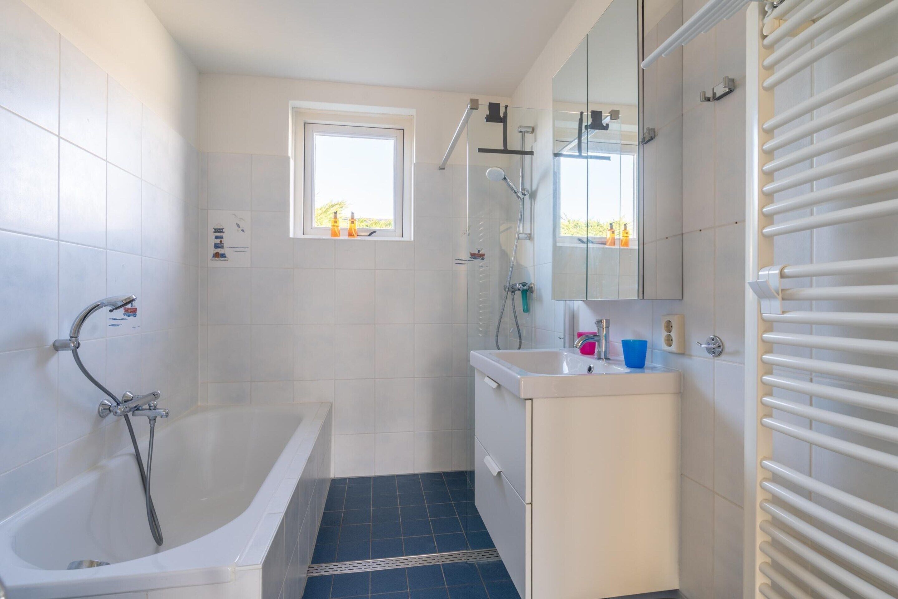 A modern bathroom with a bathtub, a shower, and a sink.