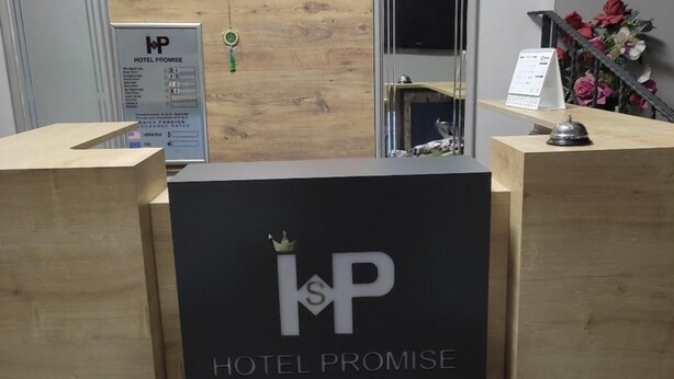 A reception desk with a black sign reading "Hotel Promise" and a crown logo. - PROMISE HOTELS HOMES AND APARTMENT (Lagos)