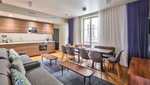 A modern apartment with a kitchen, dining area, and living room.