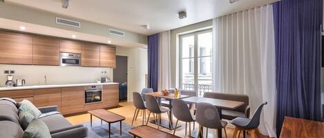 Un appartement moderne comprenant une cuisine, un coin repas et un salon.