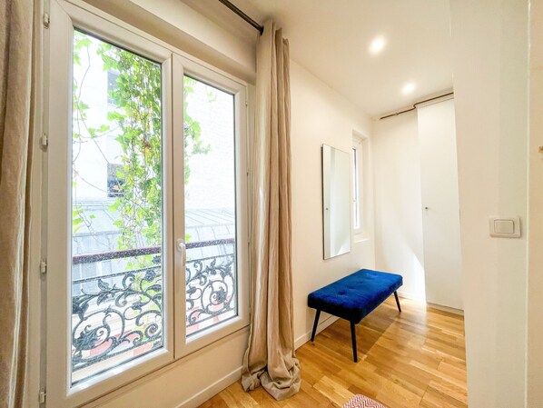 A room with large windows, a bench, and a door.