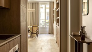 Una cocina moderna con armarios de madera, horno empotrado y comedor con mesa y sillas.