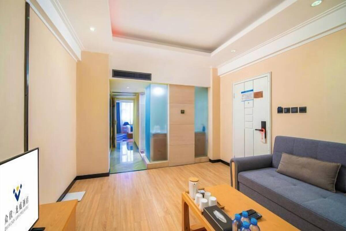 A hotel lobby with a reception desk, a sofa, a coffee table, and a glass partition wall.