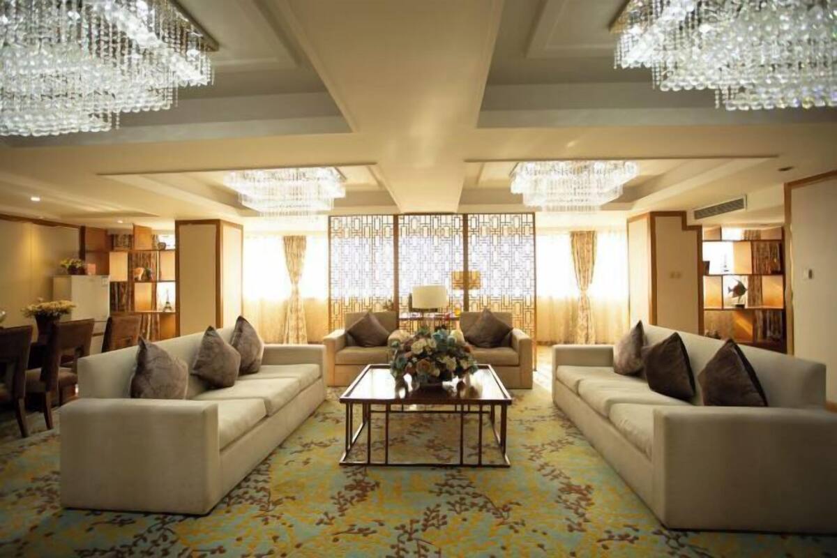 A spacious living room with two sofas, a coffee table, and a decorative screen.