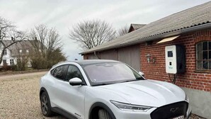 A white SUV parked in front of a brick building with a charging station. - 5 Star Holiday Home in Haderslev (Haderslev)